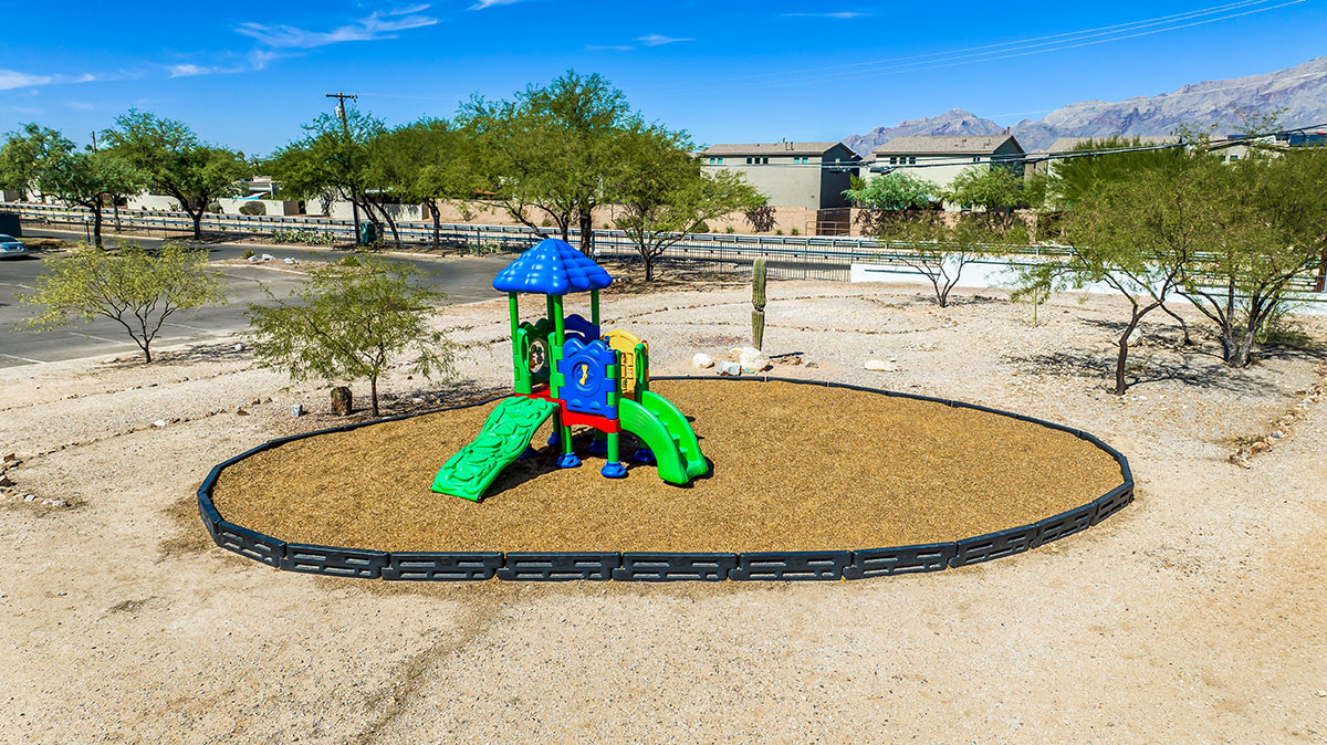 Outdoor play structure inside a fenced play area.